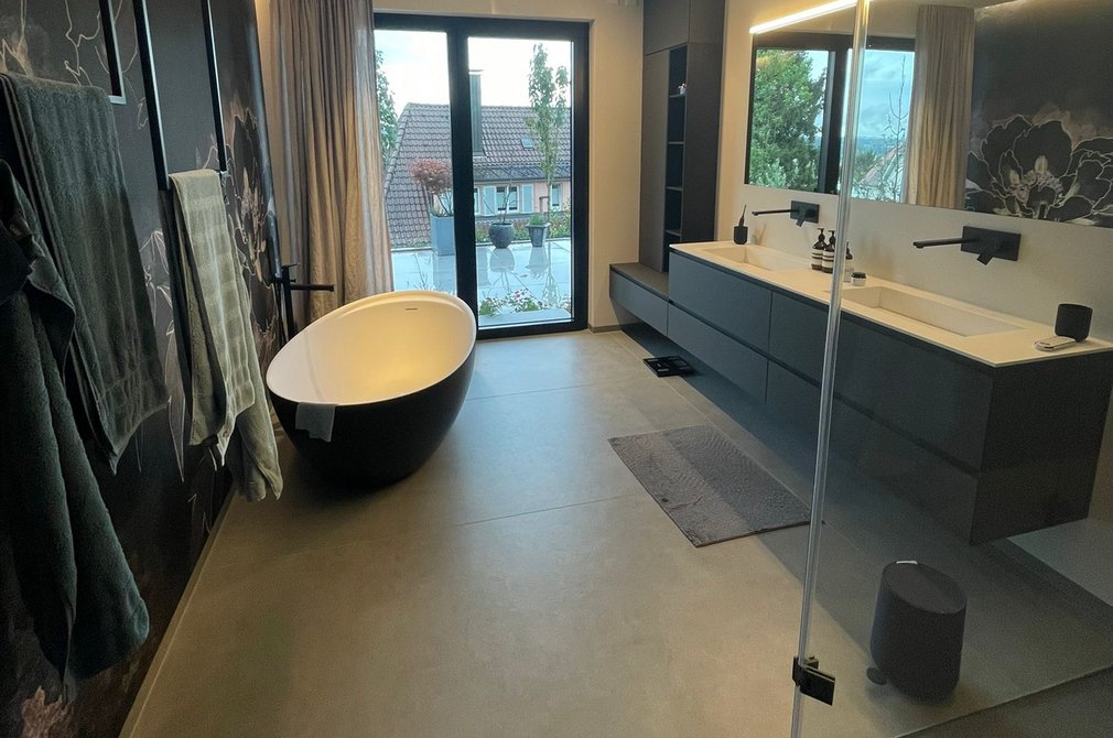 Luxusbad in Ravensburg Ein modernes Badezimmer mit dunklen Wänden und gläserner Dusche